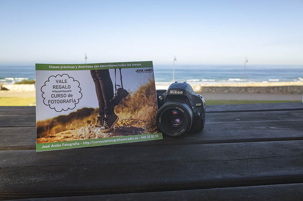 Vale regalo de fotografía apoyado en una cámara de fotos